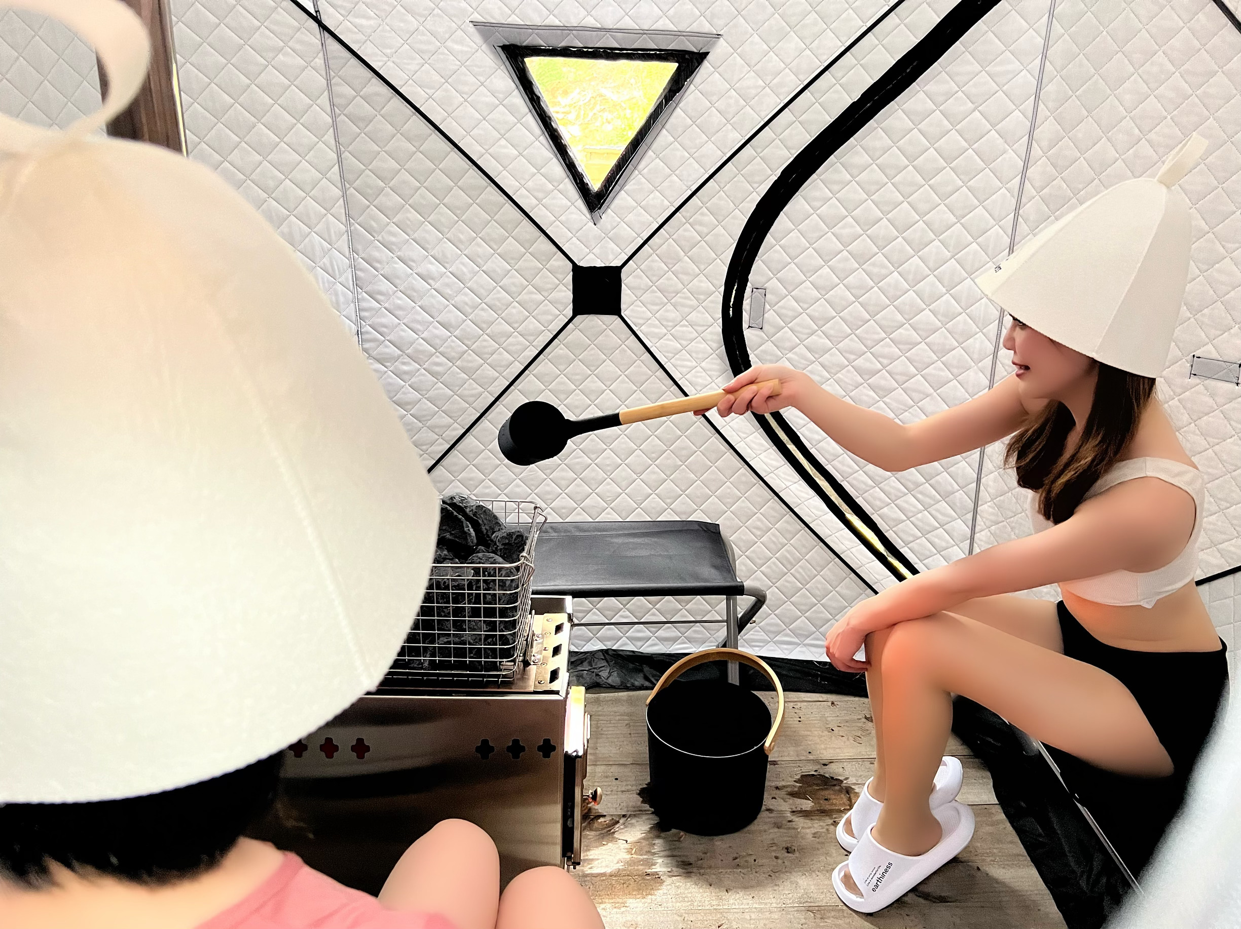 女性二人がテントサウナの中でロウリュを楽しんでいる様子